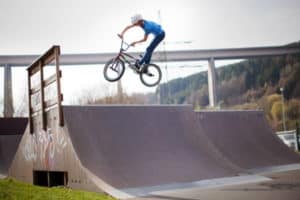 Junge springt mit BMX auf Rampe