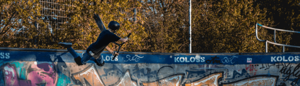 Junge springt mit Scooter