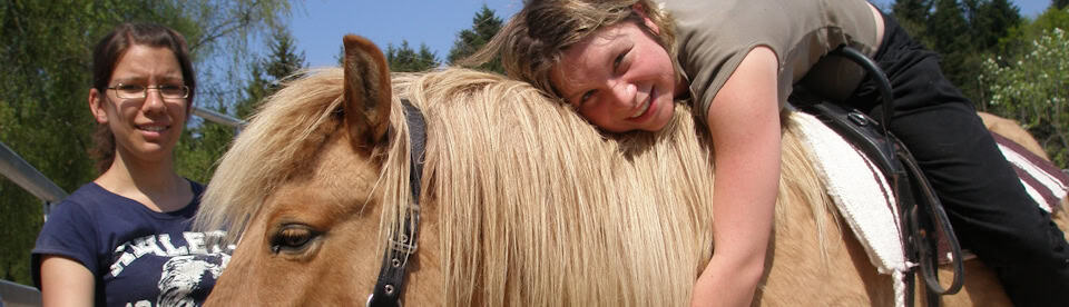 Ein Mädchen kuschelt mit dem Pferd