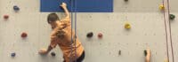 Ein Junge klettert an der Kletterwand