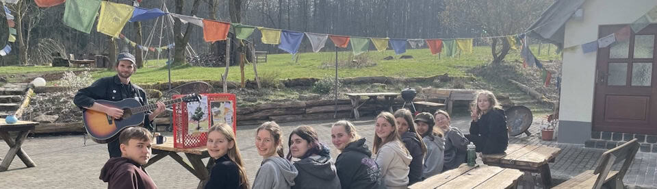 Jugendliche sitzen auf dem Außengelände