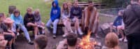 Jugendliche sitzen am Lagerfeuer