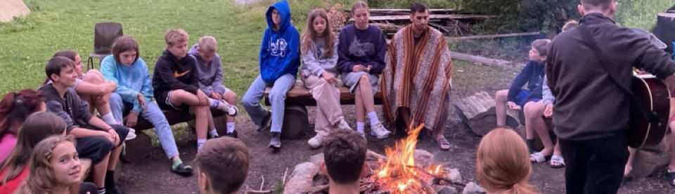 Jugendliche sitzen am Lagerfeuer
