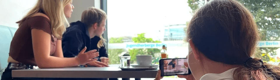 Drei Mädchen filmen eine Szene am Tisch