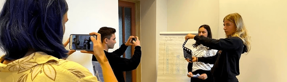 Zwei Mädchen und zwei Junsg filmen mit dem Handy eine Szene