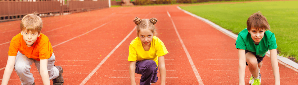drei Kinder sind in Startposition zum Sprint von vorne zu sehen