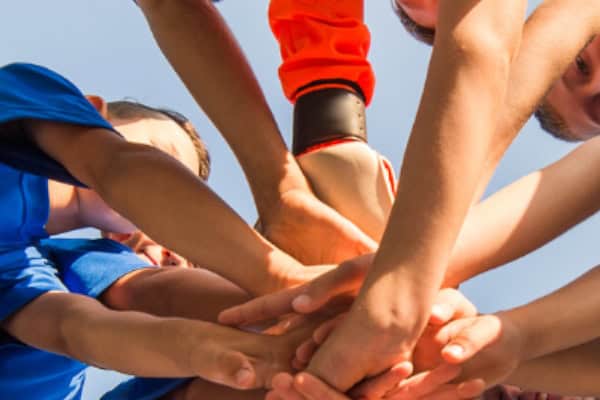 Kinder legen die Hände zusammen als Motivation