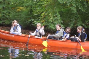 Teilnehmer beim Kanu fahren im Sport- und Action Daycamp
