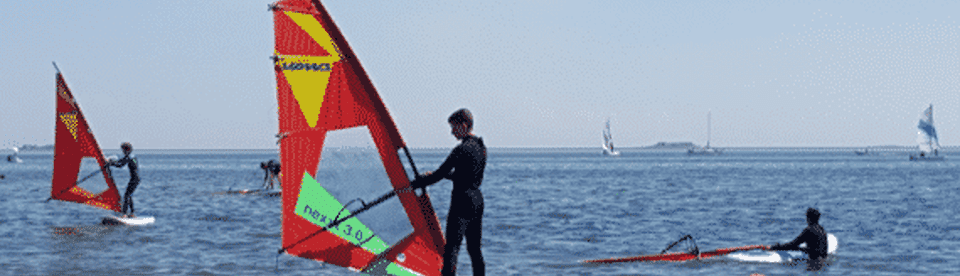 Junge steht auf Surfboard im Wasser