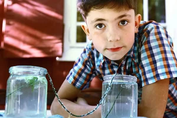 Junge beim Experiment im Englisch & Erlebnis Daycamp Wannsee