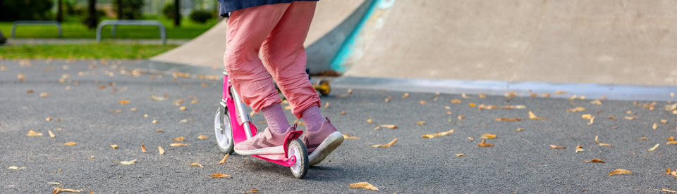 Mädchen übt Tricks auf dem Scooter