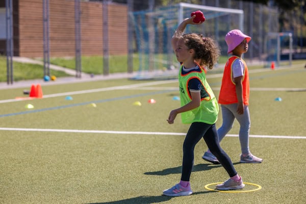 Mädchen wirft einen Ball im Athletikcamp