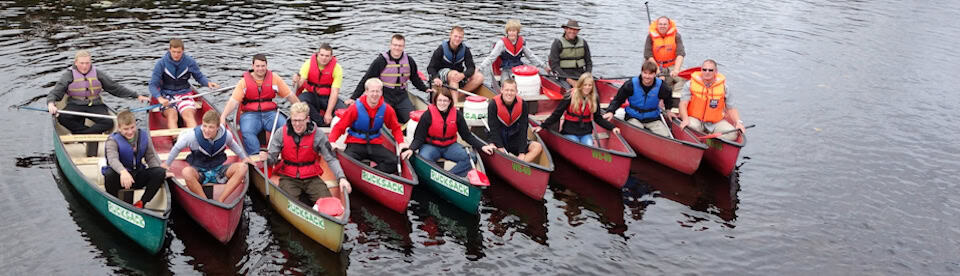 Campteilnehmer in Kanus auf dem Wasser