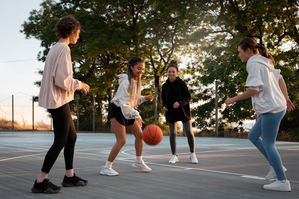 Kinder spielen auf einem Freiluftplatz Basketball