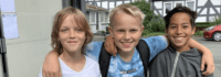 Drei Jungs lachen und umarmen sich