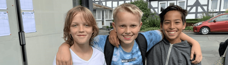 Drei Jungs lachen und umarmen sich
