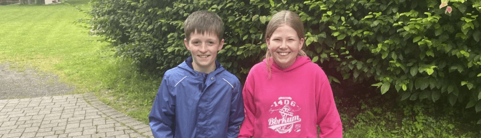 Mädchen und Junge lachen in die Kamera