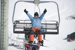 Snowboarder sitzt in einem Sessellift