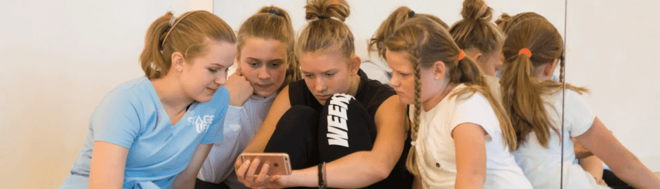 Vier Mädchen schauen auf ein Handy