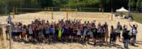 Kinder beim Gruppenfoto auf dem Beachvolleyballfeld