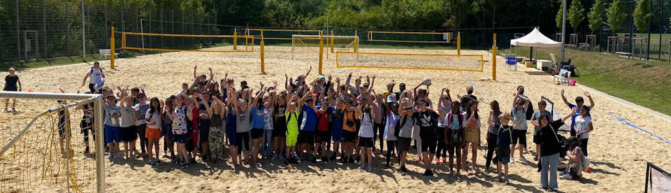 Kinder beim Gruppenfoto auf dem Beachvolleyballfeld