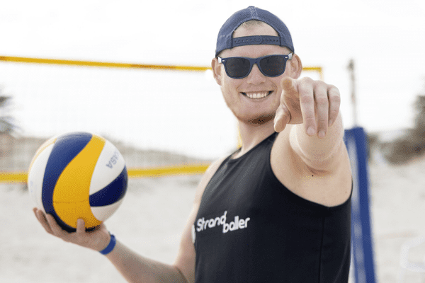 Mann mit Volleyball in der Hand im Beachvolleyballcamp in Italien
