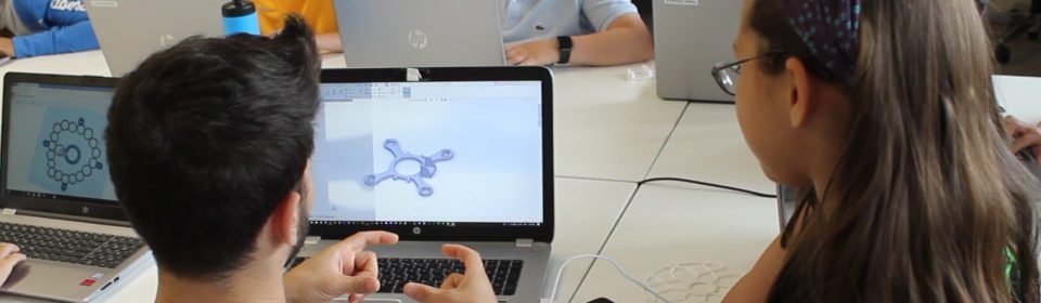 Teamer erklärt Mädchen etwas am Copmuter