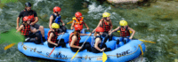 Gruppe sitzt in Schlauchboot bei Rafting Tour