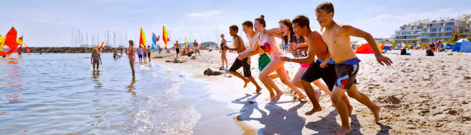 Campteilnehmer laufen ins Meer Grömitz