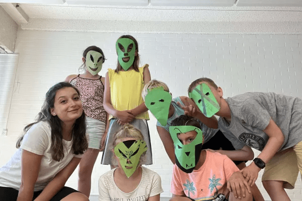 Kinder mit grünen gebastelten Masken